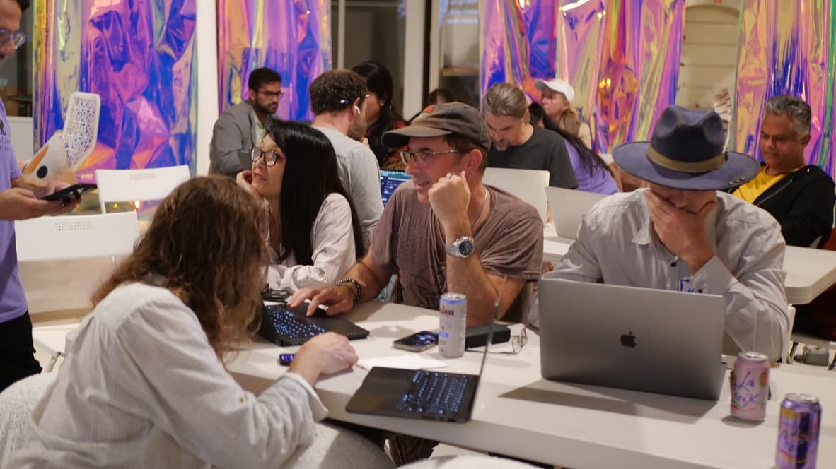 Creators collaborating at a GenJam session with colorful backdrop