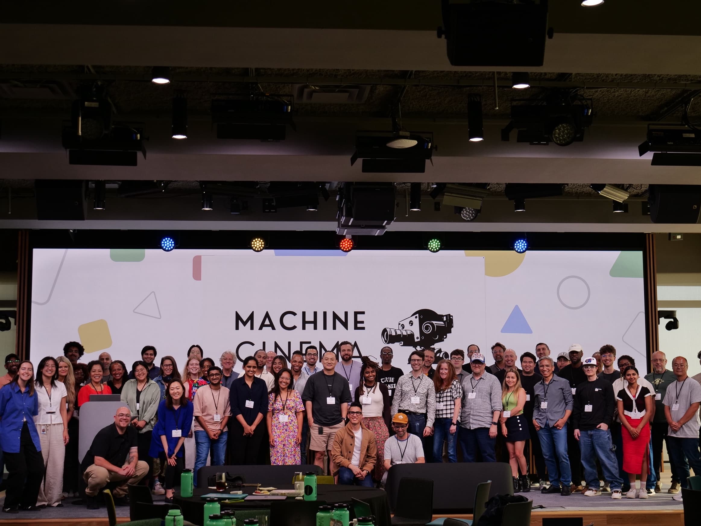 Machine Cinema community group photo with mascot backdrop
